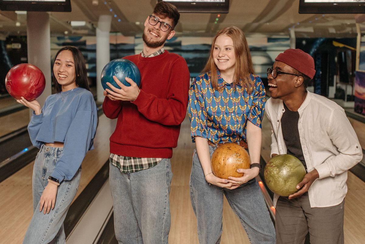 Bowlingkugel rollt auf einer Bowlingbahn auf die Pins zu